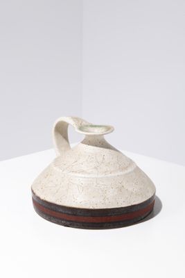 a white vase sitting on top of a white table