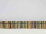 une pile de vieux livres posée sur une surface blanche