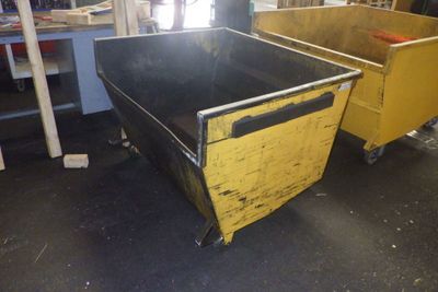 deux poubelles jaunes et noires placées l'une à côté de l'autre dans une pièce