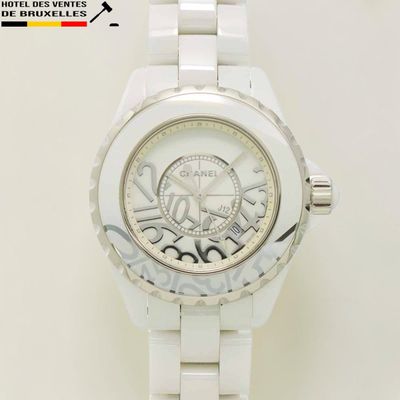 La montre est blanche et possède un cadran blanc.
