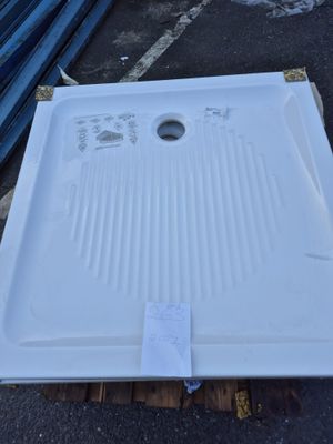 un évier blanc posé sur une palette dans un parking