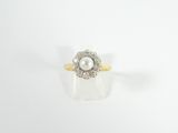 une image d'une bague en perles et diamants sur une surface blanche