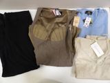 trois paires de pantalons pour homme et un t-shirt posés sur une table