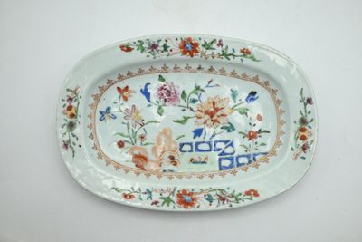 une assiette décorée de fleurs et d'oiseaux, posée sur une table
