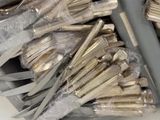 many forks and spoons wrapped in plastic on a table