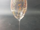 a wine glass sitting on a table with a black background
