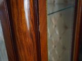 a close up of a wooden cabinet with glass doors