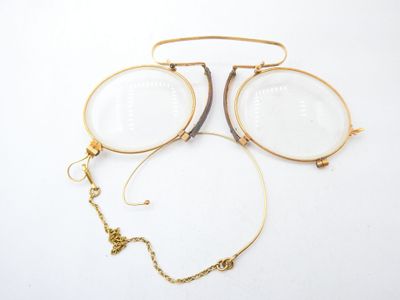 two pairs of glasses and a necklace on a white surface