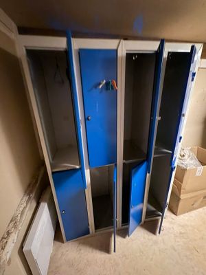 three blue lockers in the corner of a room