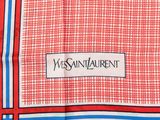 a close up of a red and green scarf with a white label on it