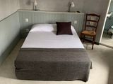 un lit qui se trouve dans une petite pièce avec une chaise
