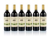 four bottles of wine are lined up on a white surface