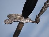 a silver sword with a black handle on a blue background