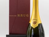 une bouteille de champagne Krug à côté d'une boîte rouge