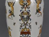 a white vase with a blue and yellow design on it