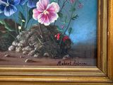 a painting of flowers in a gold frame on a blue background