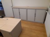 a desk and cabinets in the corner of a room