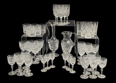 beaucoup de verres à vin et un pichet posés sur une table
