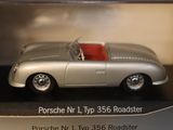 a silver toy car with a red top in a display case