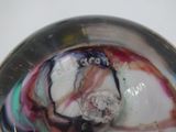 a close up of a glass object with a marble in it
