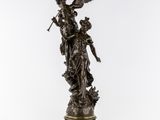 une statue en bronze d'une femme tenant un oiseau sur un piédestal