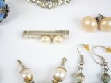 many different types of jewelry displayed on a white surface
