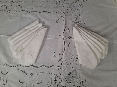 two folded napkins on top of a white table cloth