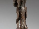 an image of a wooden statue of a man holding a baby