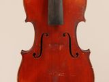 an old violin sitting on top of a white surface