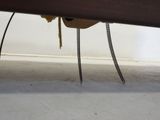 a cat that is sitting under a table with a chain