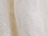 a white wedding dress hanging on a wall next to a window