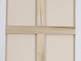 a close up of a window frame with a wooden cross on it