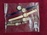 four different watches in a plastic bag on a red surface