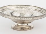 une assiette en argent antique avec un motif décoratif sur le bord