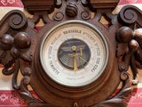a clock on the wall that has a barometer on it