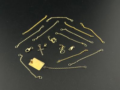 a collection of gold necklaces and bracelets on a black surface