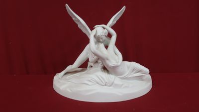 statue représentant une femme assise sur un lit, avec deux ailes sur la tête
