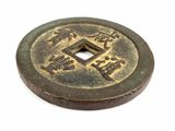 an old coin with chinese writing on it on a white surface