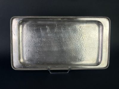 an antique silver tray with beaded edges on a black background