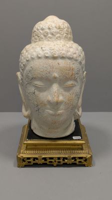 une image représentant une statue représentant une tête de Bouddha posée sur un socle