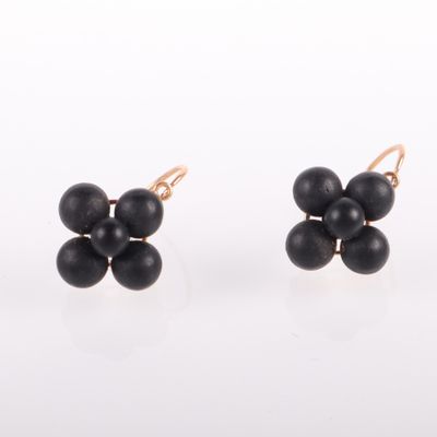 une paire de boucles d'oreilles avec des perles noires sur fond blanc