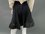 an image of a mannequin wearing a black skirt and white shirt