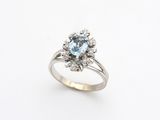 a white gold ring with a blue topaz stone surrounded by diamonds
