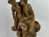 statue en bronze représentant un homme et une femme assis sur une souche d'arbre