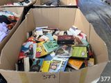 de nombreux livres dans un carton posé dans la rue