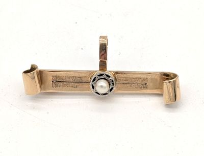 un gros plan d'une croix sertie d'une perle