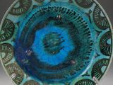 a blue and green plate with a design on it