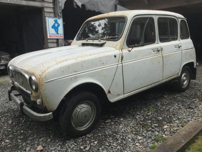 une vieille voiture blanche garée devant un garage