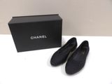 une paire de chaussures noires posée sur une table, à côté d'une boîte