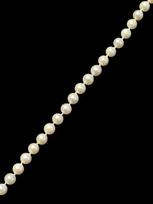 un gros plan d'un collier de perles sur fond noir